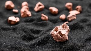 copper nuggets on top of black sand